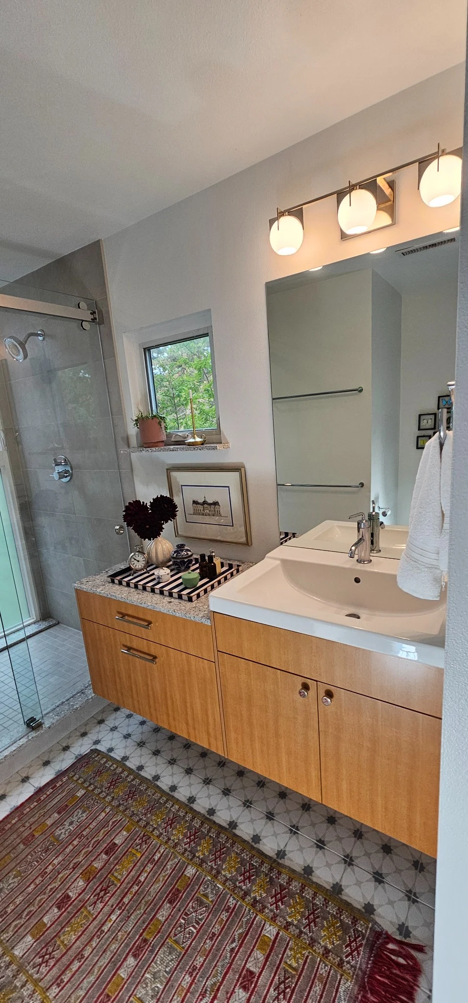 Double sink wood vanity beside the shower
