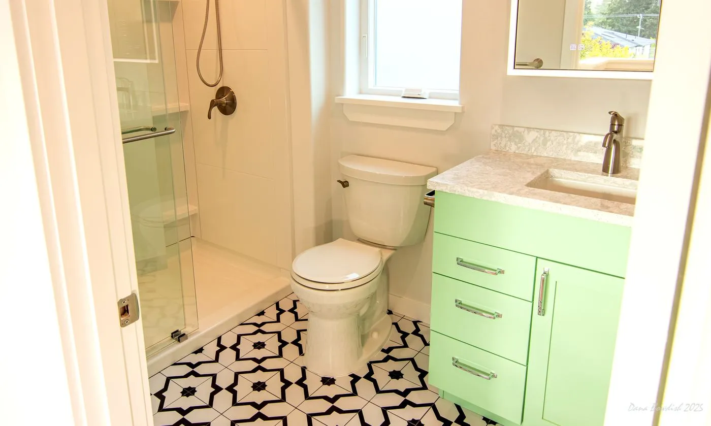 Compact bathroom layout with shower, toilet, and mint vanity