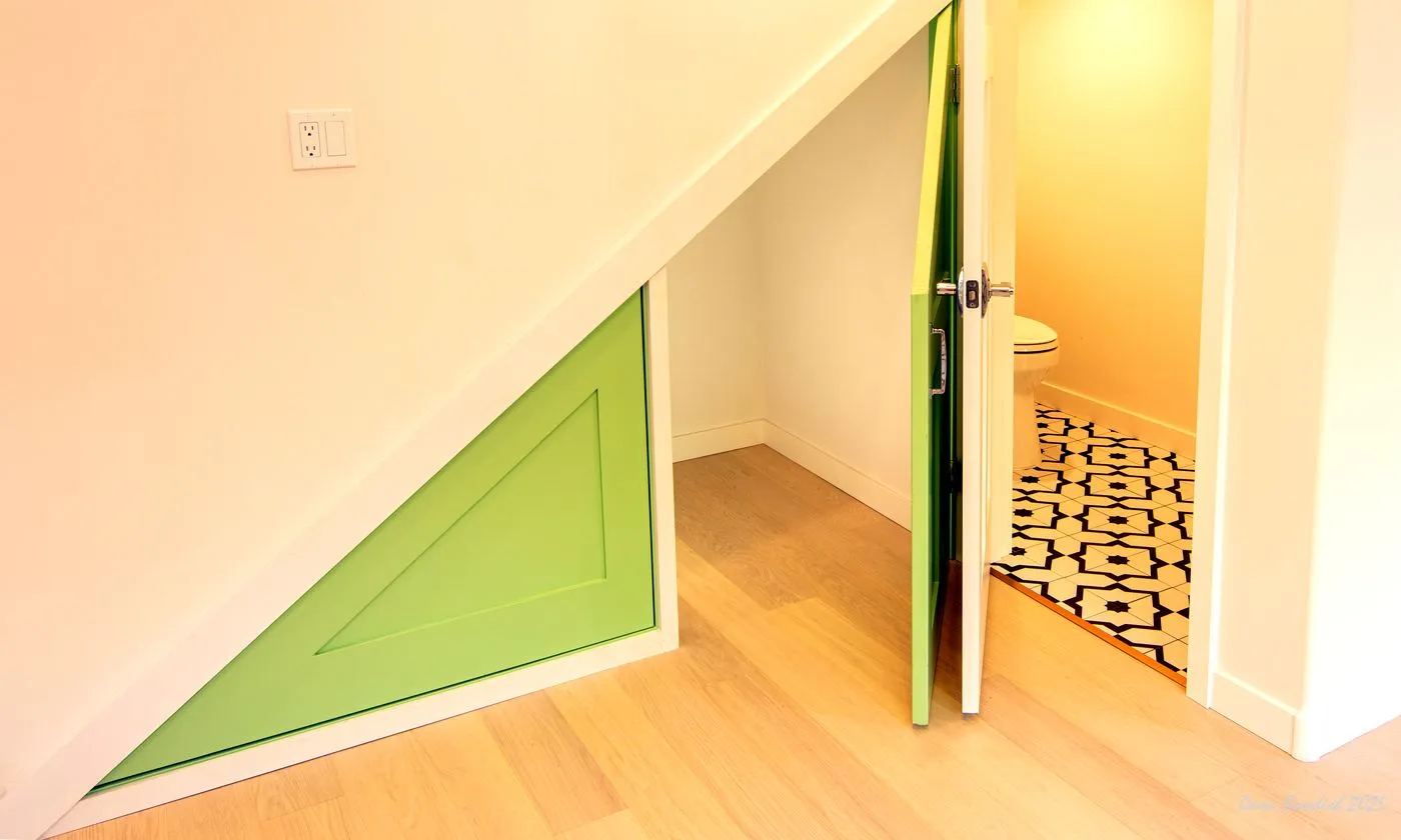 Custom triangular storage door and under-stair built-in area