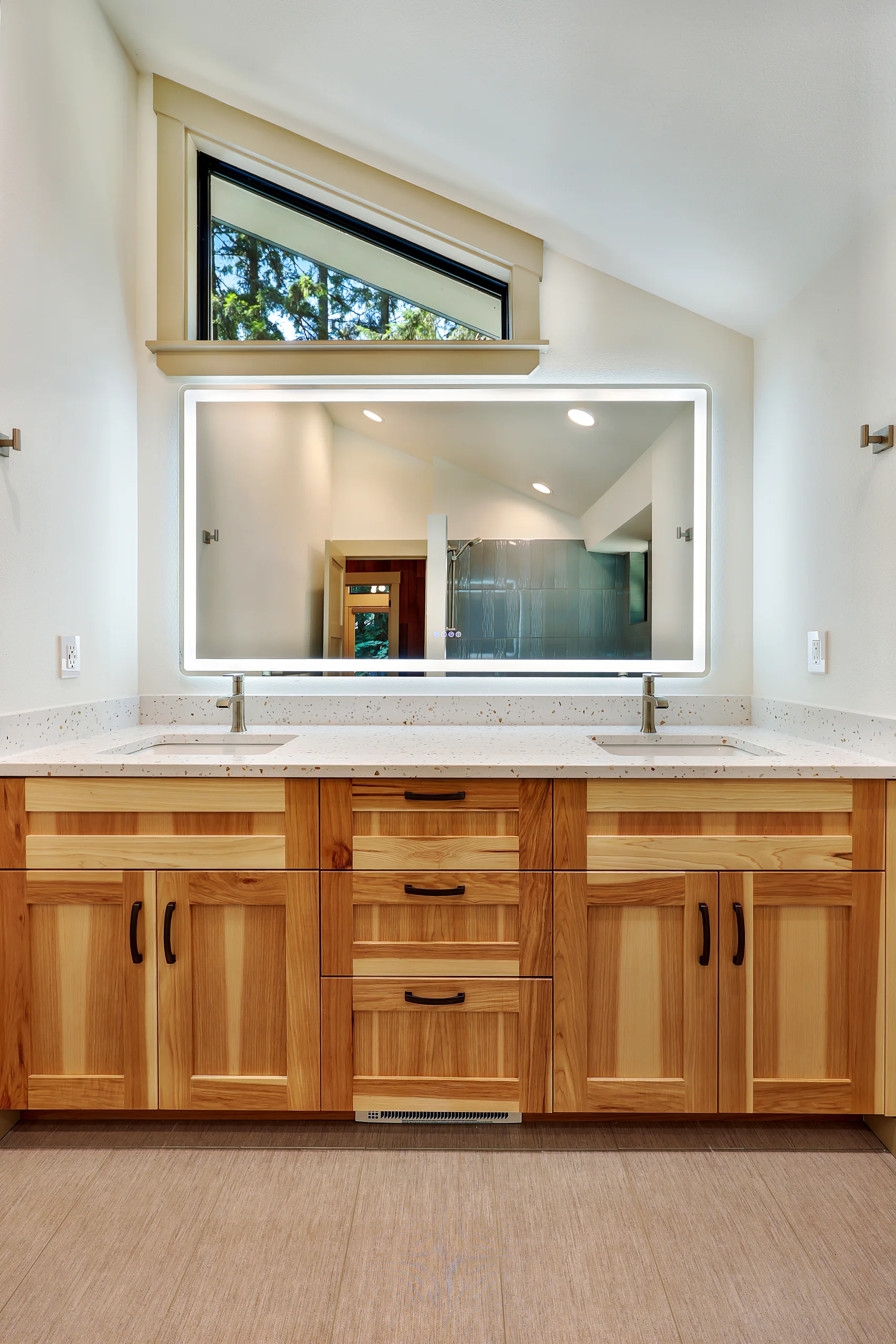 Bathroom vanity with wood cabinetry and high window