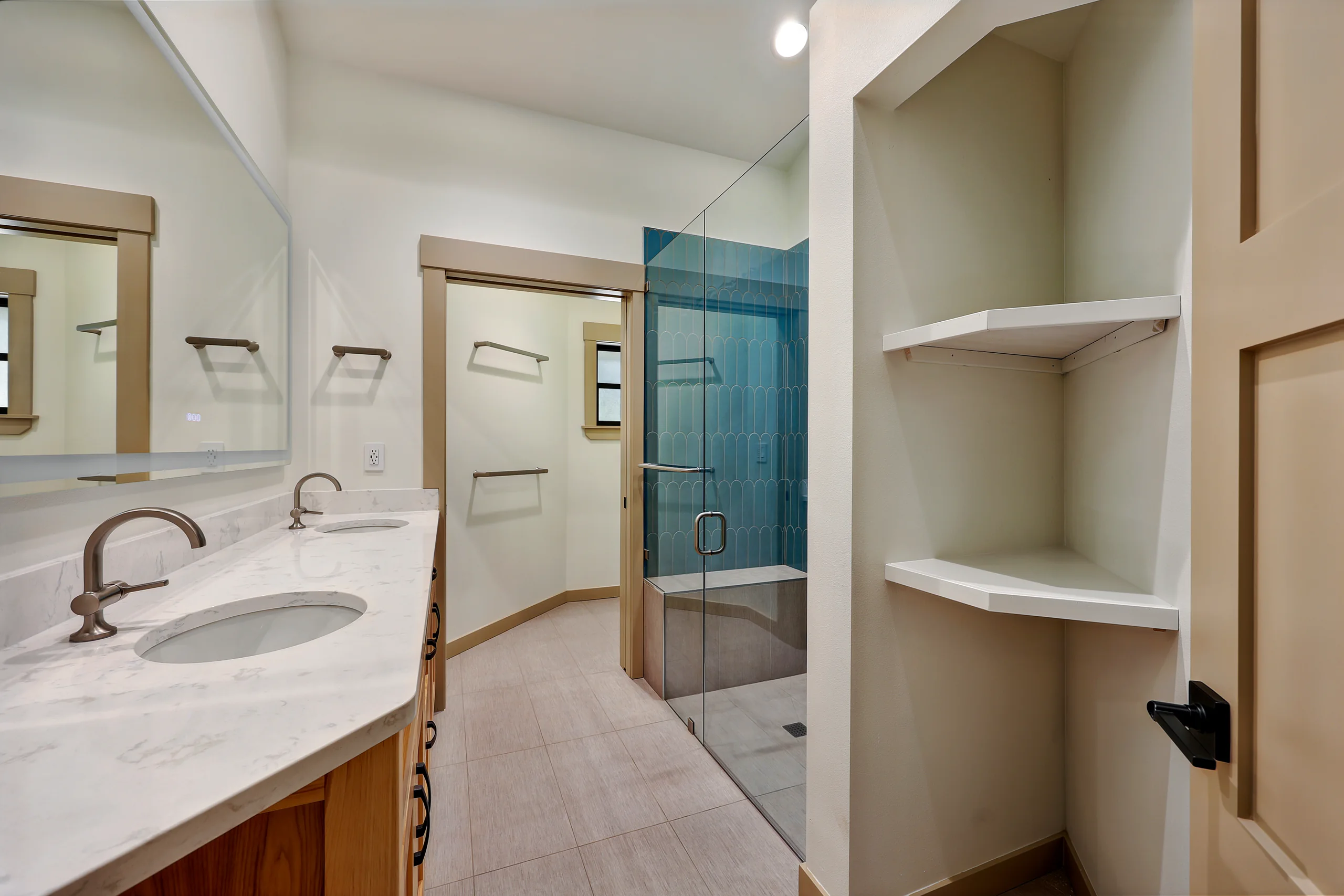 Bathroom vanity and open shelves beside the shower
