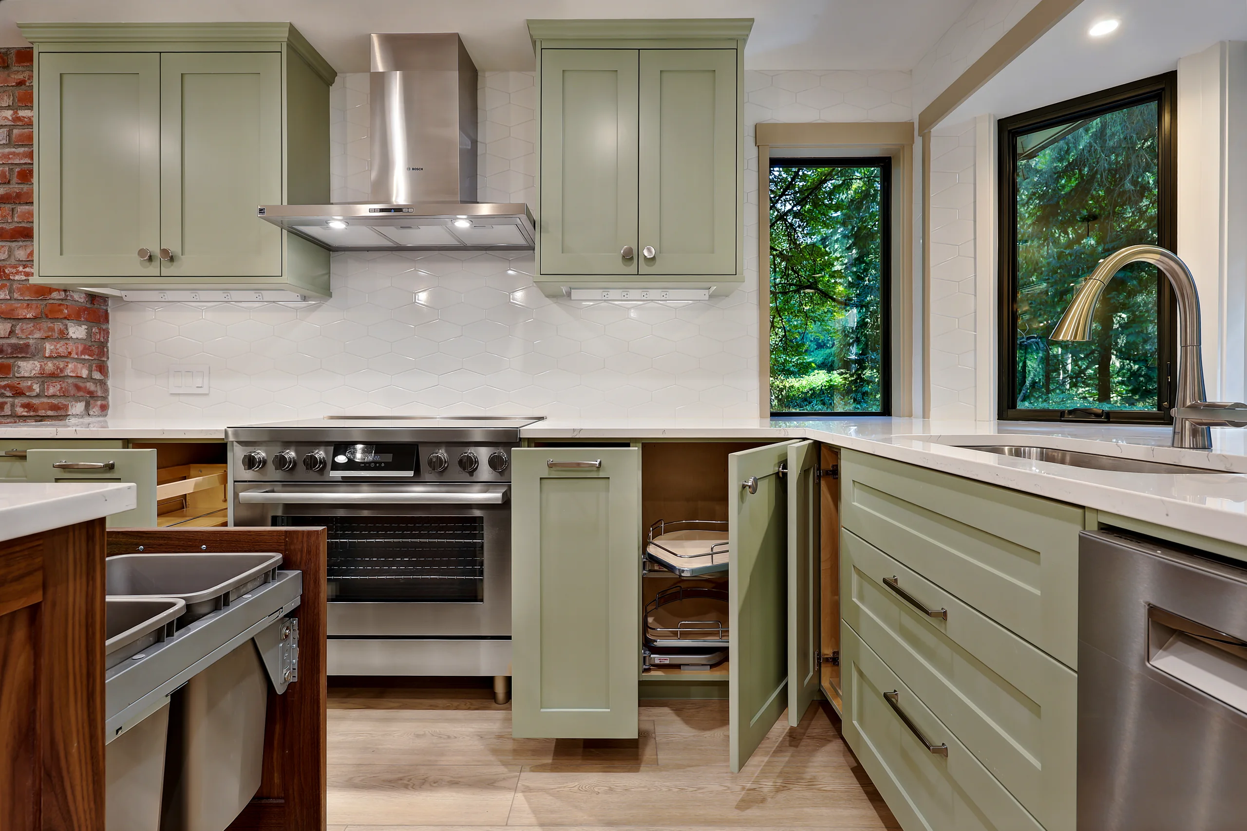 Kitchen range wall with sage green cabinets and wooded views