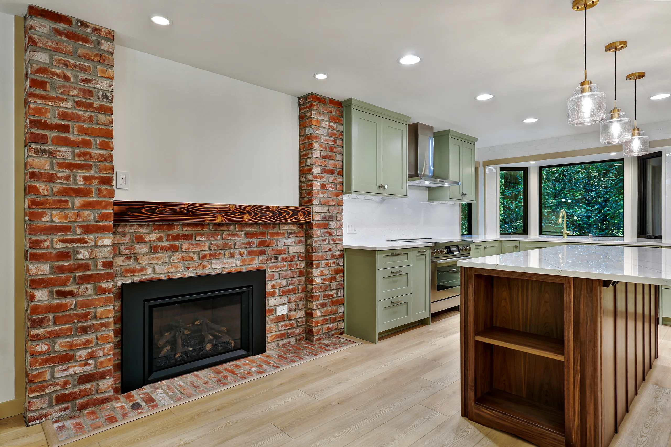 Living area with brick fireplace and adjoining kitchen