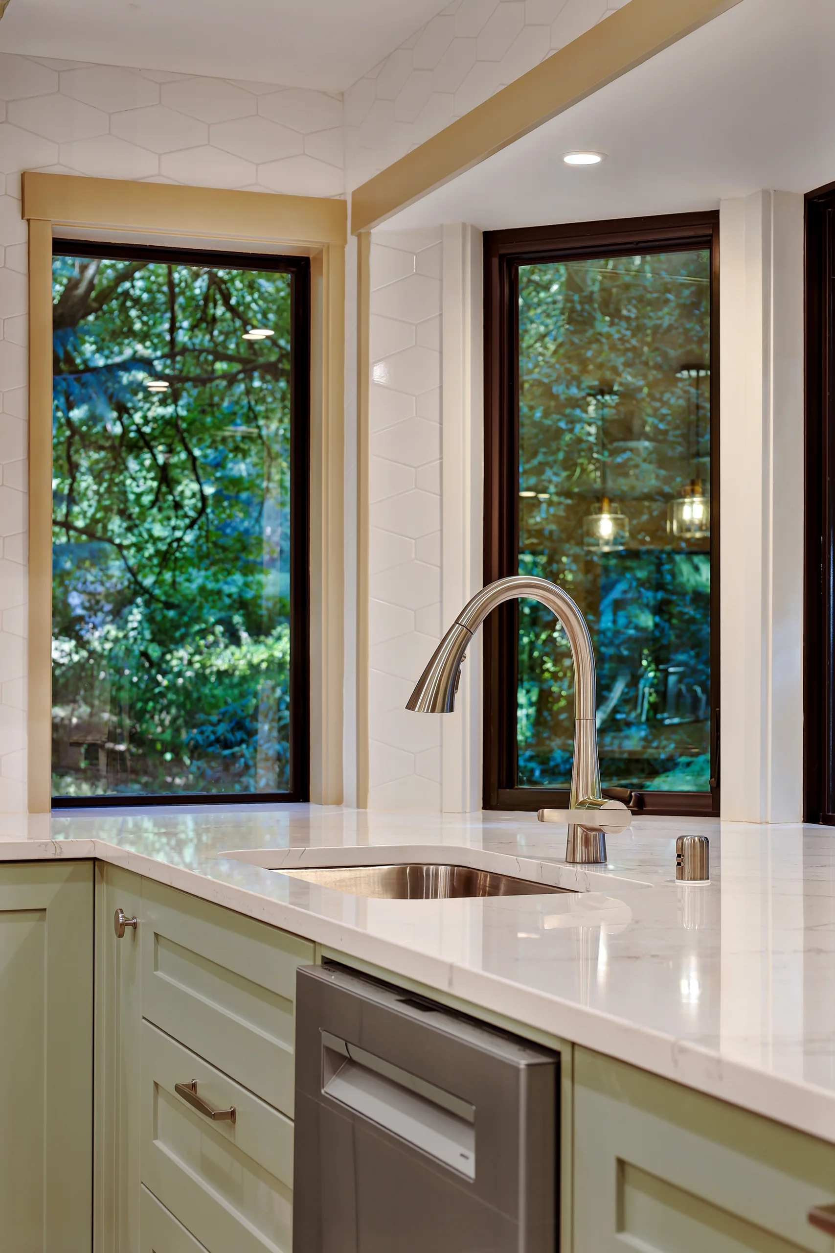 Kitchen sink and large windows overlooking the trees