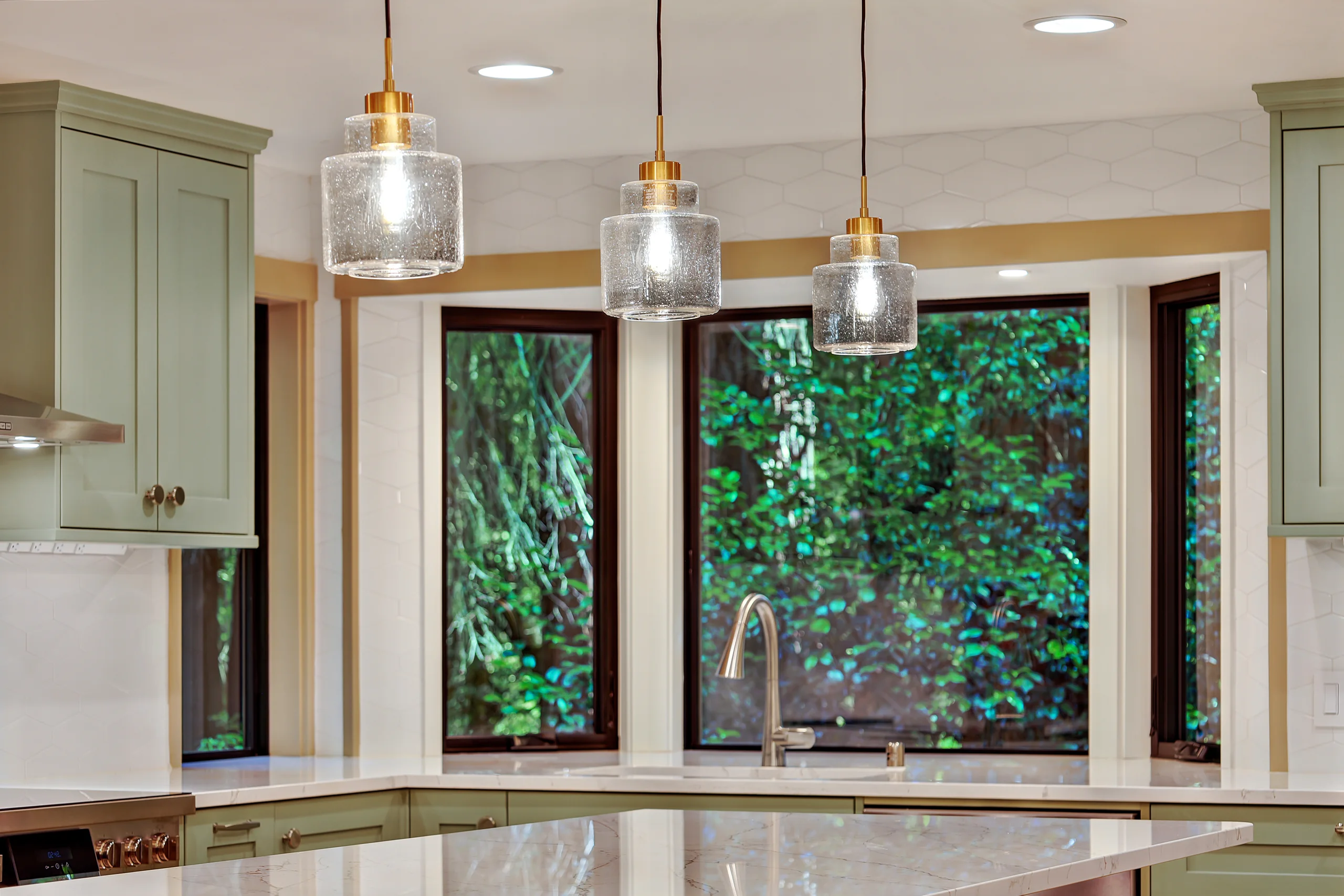 Kitchen sink wall with pendant lights and wooded views